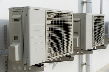 Air conditioner compressor installed on the roof of a building, along with industrial air conditioning units and ventilation systems.