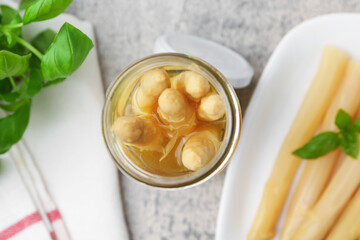 Pickled asparagus and basil on light grey table, flat lay