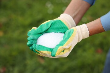 Woman with fertilizer outdoors, closeup. Gardening time