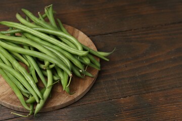 Fresh green bean pods on wooden table, closeup. Space for text
