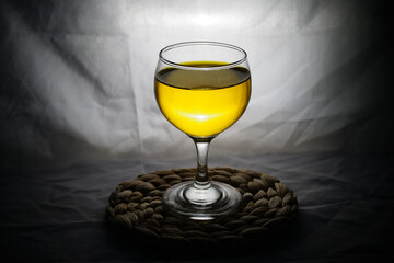 A wine glass with a golden yellow drink is served.
