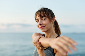 Portrait os a happy beautiful woman exercising and stretching outdoors