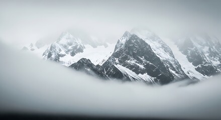 Obraz premium Majestic Snow-Capped Mountains Emerging from Ethereal Fog