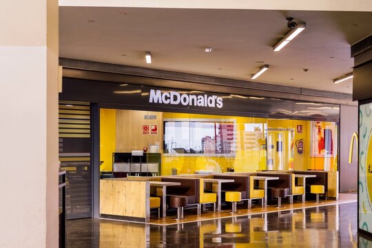 Barcelona, Spain - March 19, 2023. McDonald's Corporation is a multinational chain of fast food outlets based in the United States, founded in 1940. Tables inside the establishment