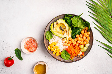 Poke bowl with spinach, avocado, corn, green salad, chickpeas, carrot and rice, white background, top view. Concept of healthy eating, dieting