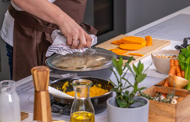 Chef preparing fresh ingredients in a modern kitchen, showcasing cooking techniques with vibrant vegetables, emphasizing creativity and nourishment in home-made dishes