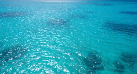 Fototapeta premium Crystal Clear Turquoise Ocean Water with Gentle Waves and Sunlight Reflections