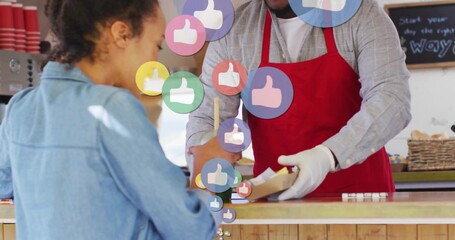 Receiving mid adult woman in denim jacket accepting paper tray inside coffee shop, digital icons