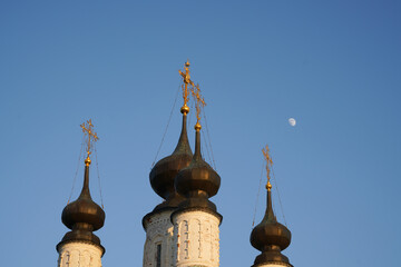 An Orthodox church with four domes topped with crosses against the blue evening sky. High quality photo