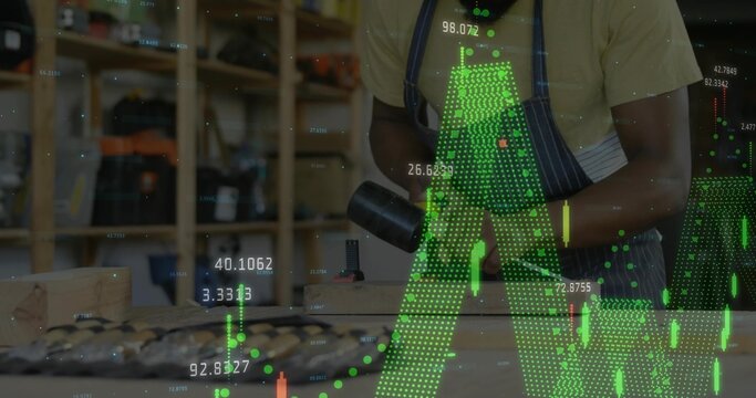 Woodworker in T-shirt and apron using heat gun on plank in workshop, with stock data overlays