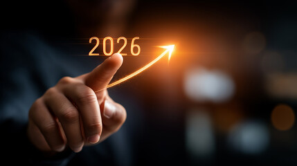Obraz premium Determined leader hands touching 2026 with target arrow hologram representing new year business goals and success roadmap on dark background. business goals 2026 strategic vision