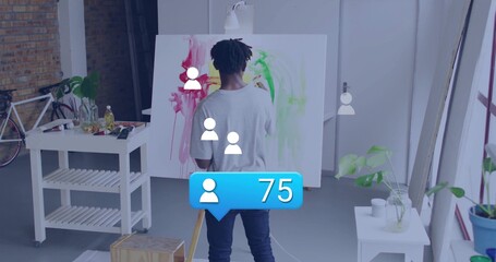 Painting artist applying red yellow strokes on canvas in art studio loft, with easel and bicycle
