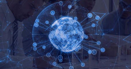 Displaying holographic networked globe above table in conference room, with team typing on laptops