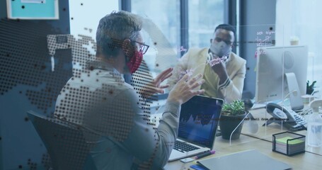 Masked colleagues analyzing data charts on laptop at office desk, with plexiglass divider notes