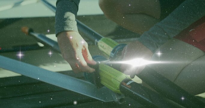 Fototapeta Securing athlete fastening carbon-fiber oars into oarlocks on dock, wearing grey top and red shorts