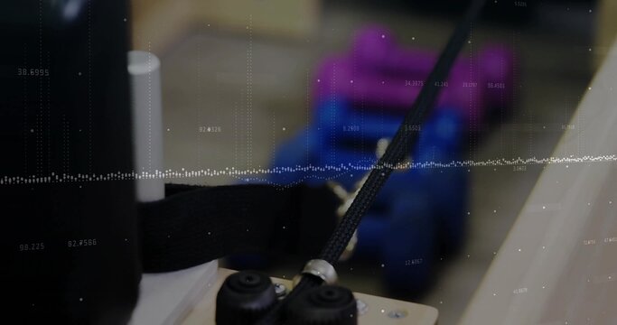 Braided cable assembly moving through metal guide on wooden block in workshop, with support rollers - Powered by Adobe