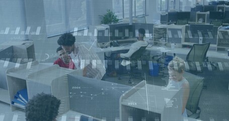 Leaning woman in white blouse pointing to computer screen at cubicle in open-plan office