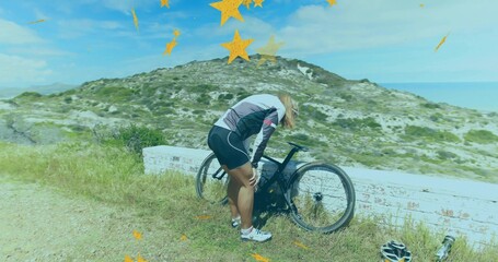 Inspecting woman cyclist in cycling jersey adjusting bike component on coastal trail, with helmet