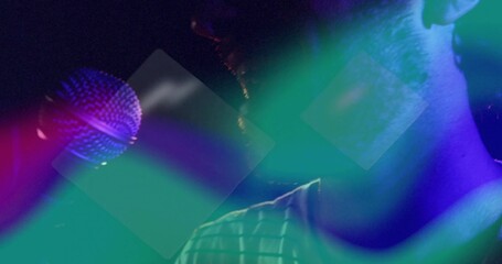 Performing singer wearing striped shirt singing under neon haze at nightclub, with handheld mic