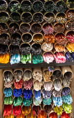 Close-up of multiple colored glass rods, ready for artistic glass jewelry. The image shows a wide range of brilliant hues. Craft shop in Rupit, Spain.