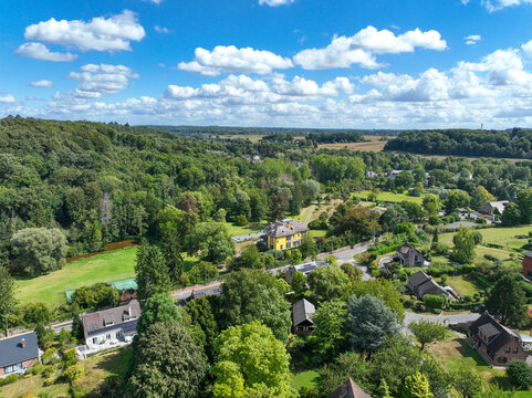 Aerial view of Genappe municipality and city of Wallonia located in the Belgian province of Walloon Brabant. Villas with garden surrounded by forest.
