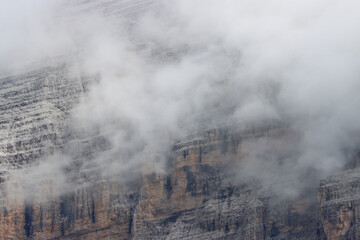 A Dolomite cliff cloaked in thick, white rain clouds