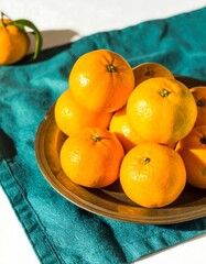 Fresh oranges piled high on a brass platter