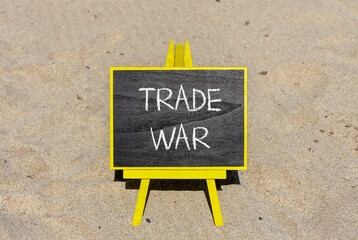 Trade war symbol. Concept word Trade war on beautiful black blackboard. Beautiful sand beach...