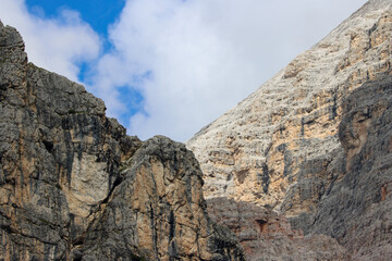 Rocky cliffs beneath a cloud-streaked blue sky