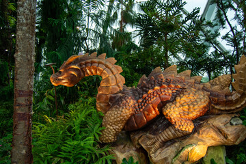 Wooden dragon sculpture in a lush garden