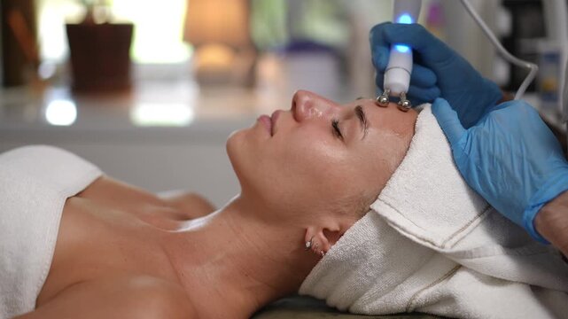 A woman enjoys a hydrafacial treatment in a tranquil spa, enhancing her natural beauty and radiant glow