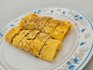 Homemade Malaysian omelette roll served on vintage floral plate, authentic traditional breakfast and cultural heritage cuisine presentation