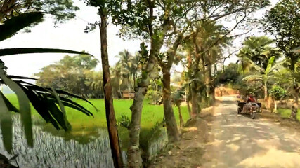 Scenic Rural Landscape with Lush Greenery and a Motorized Vehicle on a Dirt Road in Daytime
