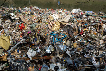 Polluted riverbank with mixed waste and debris