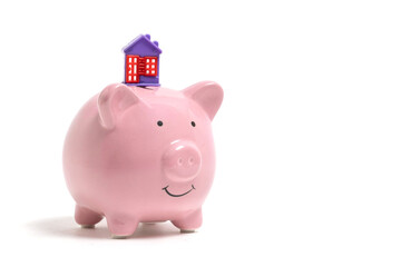 Pink piggy bank with house on white background. Saving money concept.