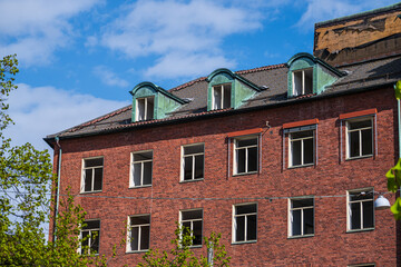 Upper floor of red brick building with green dormers.