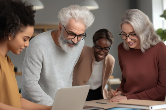 Diverse business team members working together, brainstorming ideas, and smiling while collaborating on a laptop during an office meeting, demonstrating teamwork and professional interaction