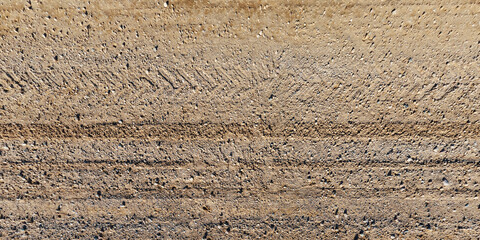 top view of gravel road surface with tractor tire tracks in countryside
