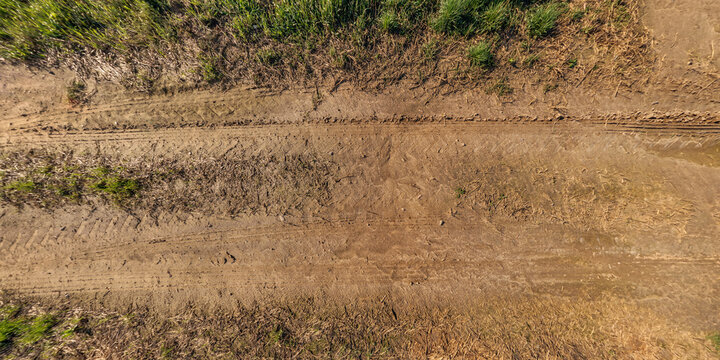 top view of gravel road surface with tractor tire tracks in countryside