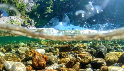 Half-underwater view of a river cascading over rocks