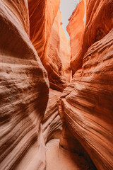 Narrow slot canyon with textured red sandstone walls, shaped by erosion, ideal for travel and desert nature themes
