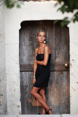 Elegant Woman Posing by Rustic Wooden Door Against Stone Wall