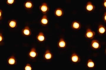 Obraz premium Blurred lights of electric garland, yellow warm light