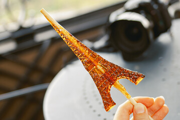 Sucking candy, caramel on a stick, in the shape of the Eiffel Tower