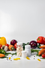 Beautiful jars of vitamins are displayed on a table surrounded by colorful vegetables such as peppers, carrots, onions, and tomatoes, representing a commitment to health and wellness.