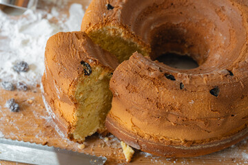 Homemade bundt cake with raisins and a sliced piece on board