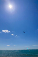 TORREMOLINOS, SPAIN - JULY 12, 2025: A passenger plane approaches for landing from the Mediterranean Sea at Malaga Airport, Spain, flying low over the coastline.