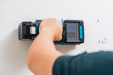 Electric Hand Using Digital Stud Finder Detecting Wires in Wall