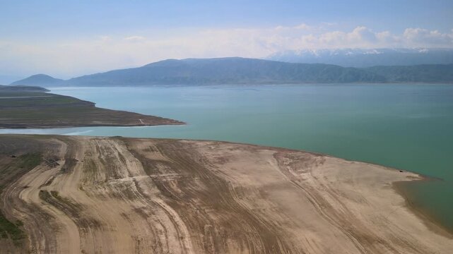 Toktogul Reservoir (284.3 km&sup2;),the largest in Central Asia.Turquoise water,sandy beaches and snow-capped Tien Shan on the horizon.Fed by the Naryn River and a major hydroelectric source (Toktogul HPP)