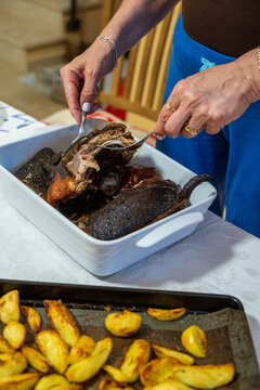 Traditional Sardinian suckling pig, artisanally cooked at home with potatoes on a family table.